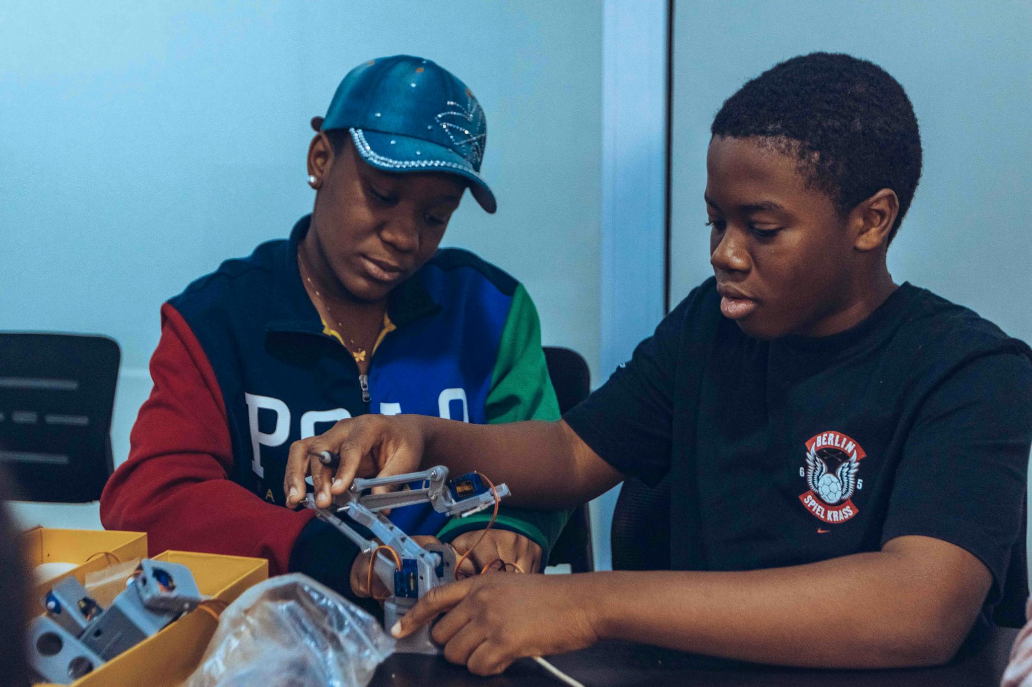 Two students assembling a robot in a hands-on STEM workshop in Accra, Ghana.