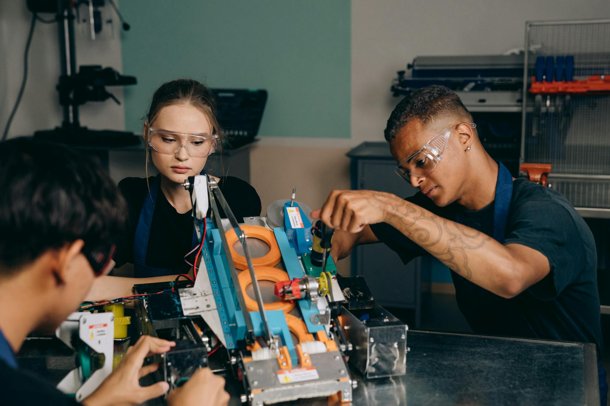 Young engineers collaborating on a robotics project in a workshop setting.